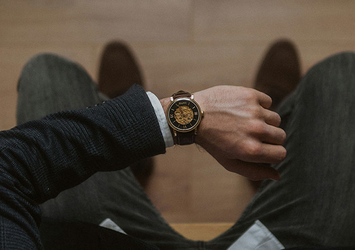 Man wearing an elegant watch and dark sweater, highlighting accessories women obsess over for no reason at all.
