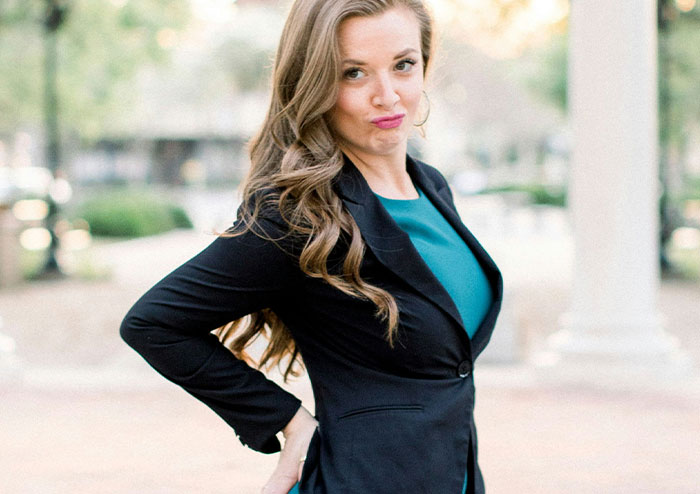 Young woman in business attire posing confidently outdoors, illustrating what women obsess over for no reason at all
