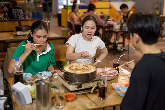Group of people eating at a restaurant table, illustrating servers sharing customer horror stories and true nightmares.
