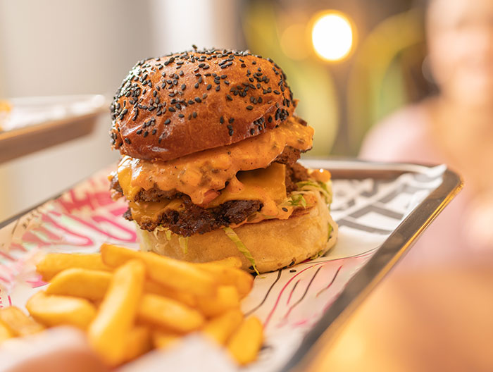 Juicy cheeseburger with special sauce and fries served on a tray, illustrating servers sharing customer horror stories.