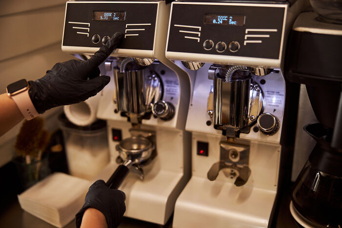 Server operating a coffee machine preparing orders, illustrating customer horror stories shared by servers in the hospitality industry.