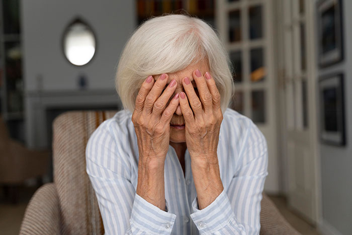 Elderly woman covering her face in distress, illustrating heartbreaking medical conditions that can’t be cured.