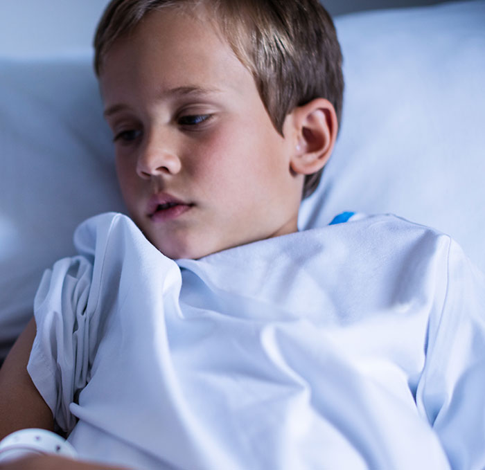 Young boy in hospital bed looking unwell, illustrating heartbreaking medical conditions that can't be cured.
