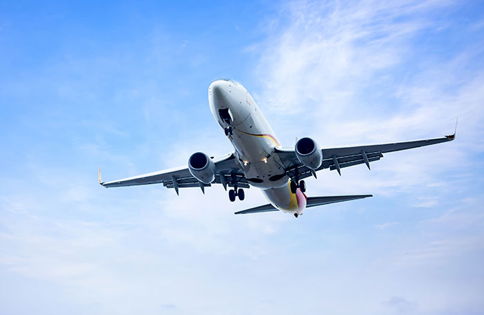 Commercial airplane flying in clear blue sky, illustrating lucky times people got out of dangerous situations.