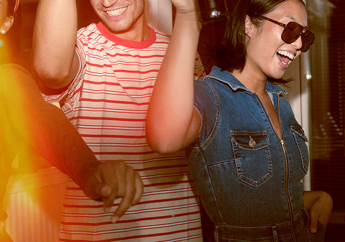 Young people enjoying a lively party, smiling and dancing, capturing close calls and memorable moments shared.