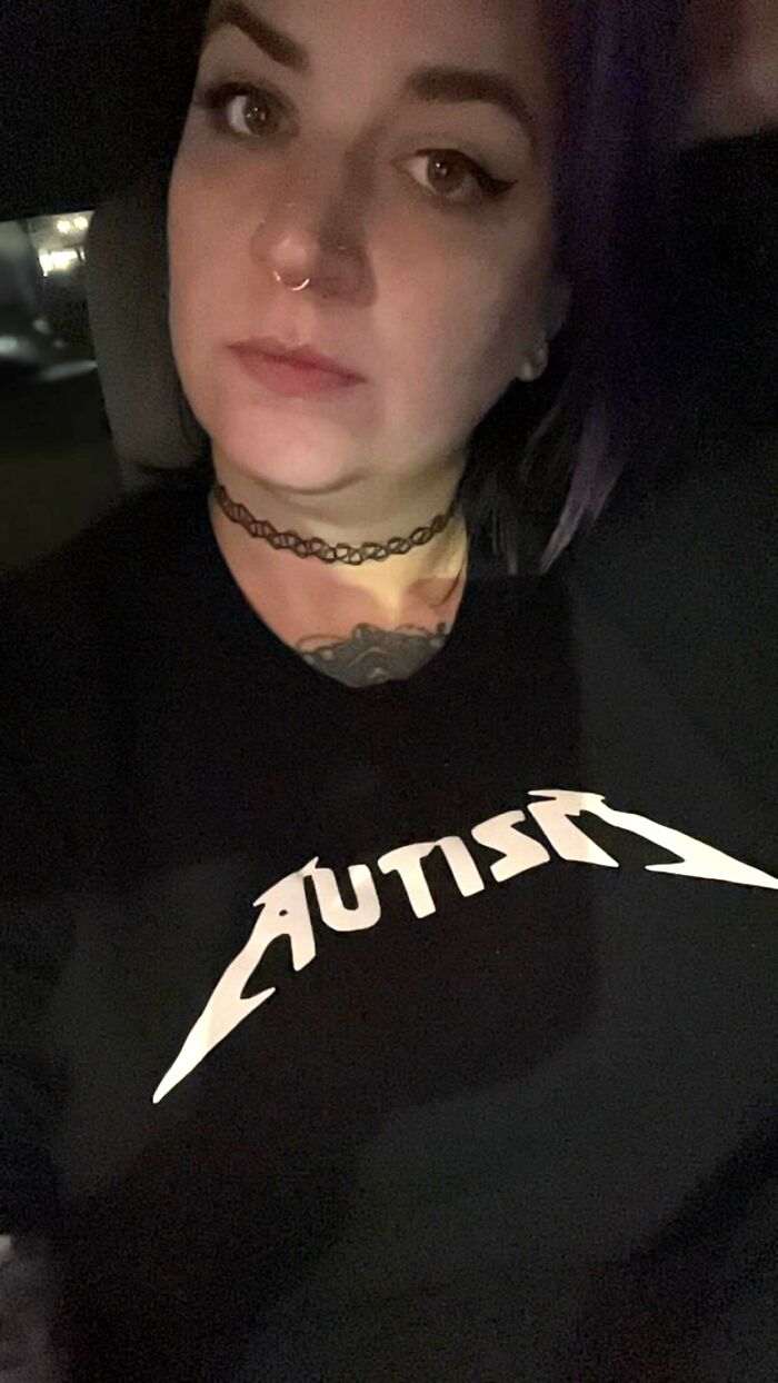 Woman wearing a choker necklace and a black shirt with bold text symbolizing life with a spicy neurodivergent brain.