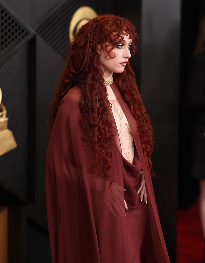 Chappell Roan in a sheer maroon outfit with long curly red hair at the Grammys sparking outrage online. Chappell Roan in a sheer maroon outfit with long curly red hair at the Grammys sparking outrage online.