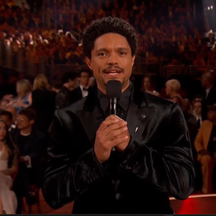 Trevor Noah speaking at the Grammys event, wearing a black suit, sparking wild theories with his bizarre statement. Trevor Noah speaking at the Grammys event, wearing a black suit, sparking wild theories with his bizarre statement.