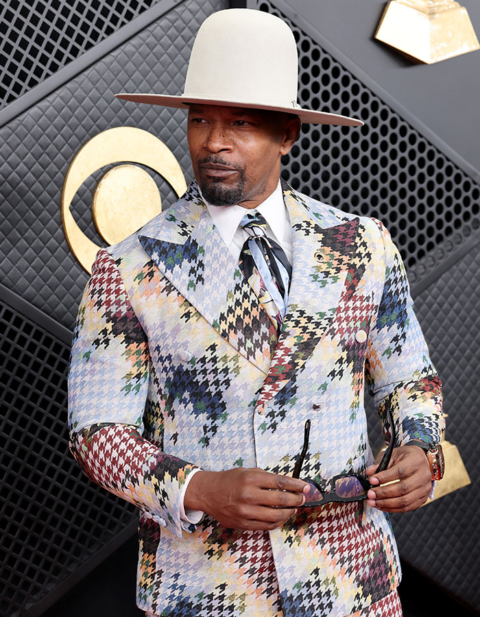 Jamie Foxx in a multicolored suit and wide-brimmed hat posing on the Grammy red carpet during a viral moment. Jamie Foxx in a multicolored suit and wide-brimmed hat posing on the Grammy red carpet during a viral moment.