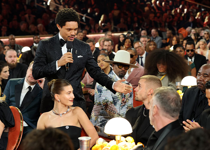 Host interacting with attendees during cringe moments at the 2026 Grammy Awards in a crowded event setting.