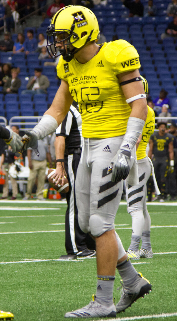 Talanoa Hufanga in yellow US Army football uniform on field during a game, preparing for a play.