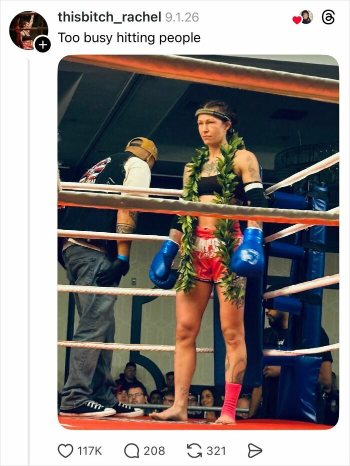 Female boxer in ring wearing gloves and a leaf garland, showing strength and confidence in a fierce moment.