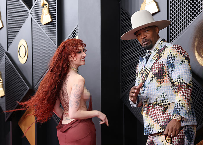 Man in colorful suit and wide-brim hat with woman in backless dress at 2026 Grammy Awards cringe moments event.
