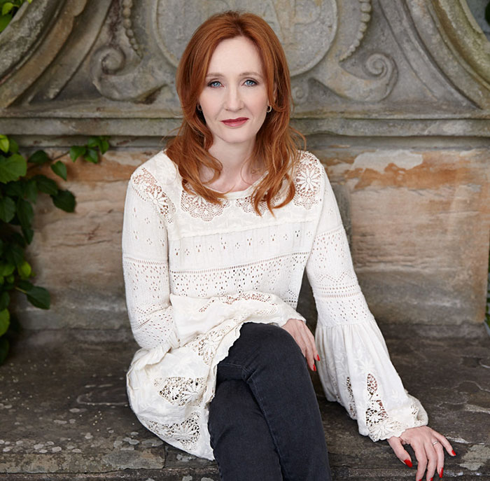 J.K. Rowling sitting outdoors in a white lace top and black pants, addressing Jeffrey Epstein accusations in a serious tone. J.K. Rowling sitting outdoors in a white lace top and black pants, addressing Jeffrey Epstein accusations in a serious tone.