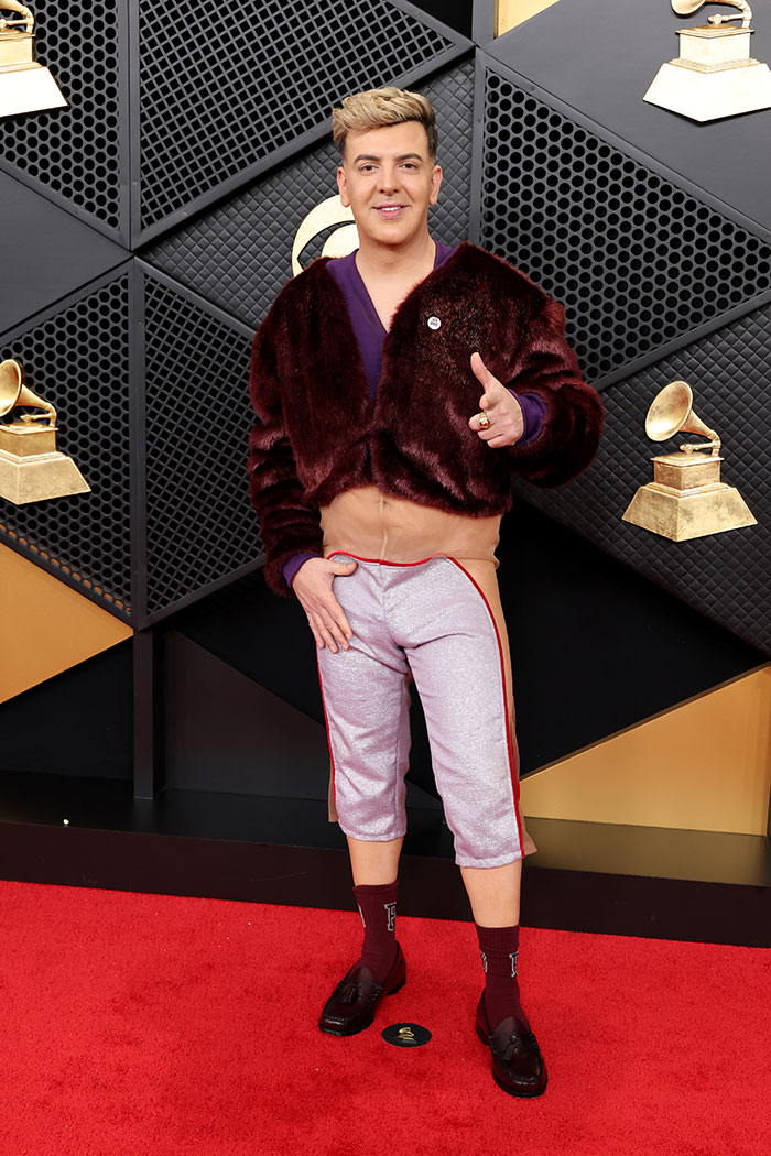 Person posing on the red carpet wearing a cropped fur jacket and cropped pants, a notable fashion fail from the 2026 Grammys.