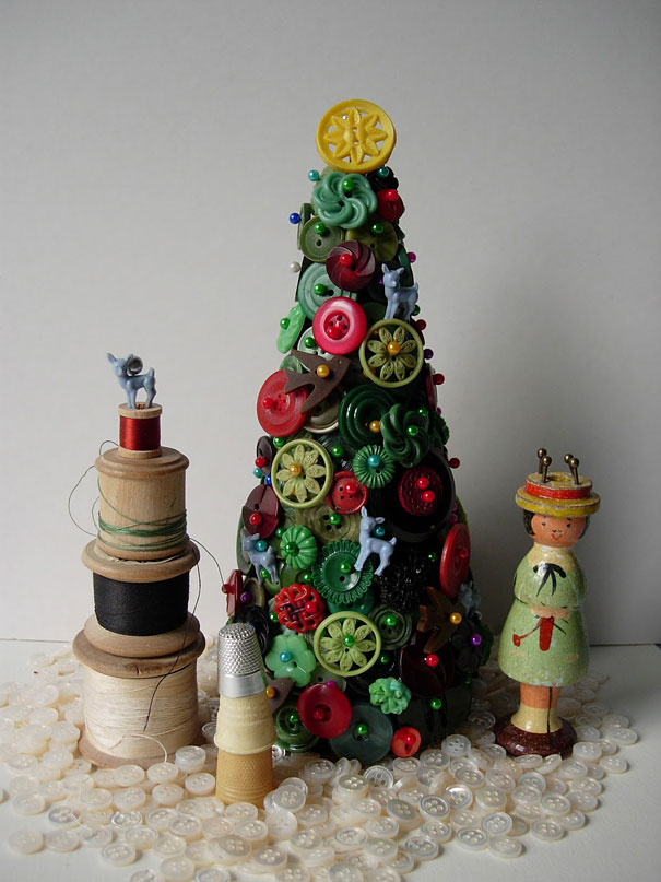 Creative DIY Christmas tree made of colorful buttons, spools, and a small doll, showcasing a unique holiday craft idea.