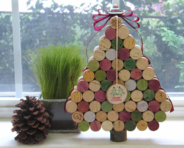 DIY Christmas tree made from colorful wine corks with festive decorations, displayed next to a pinecone. DIY Christmas tree made from colorful wine corks with festive decorations, displayed next to a pinecone.