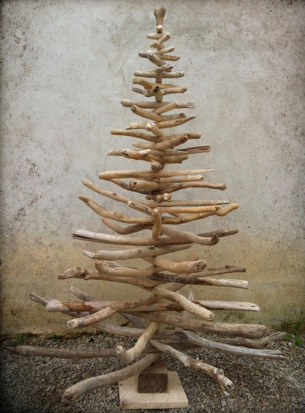 DIY Christmas tree made from stacked driftwood against a textured wall. DIY Christmas tree made from stacked driftwood against a textured wall.