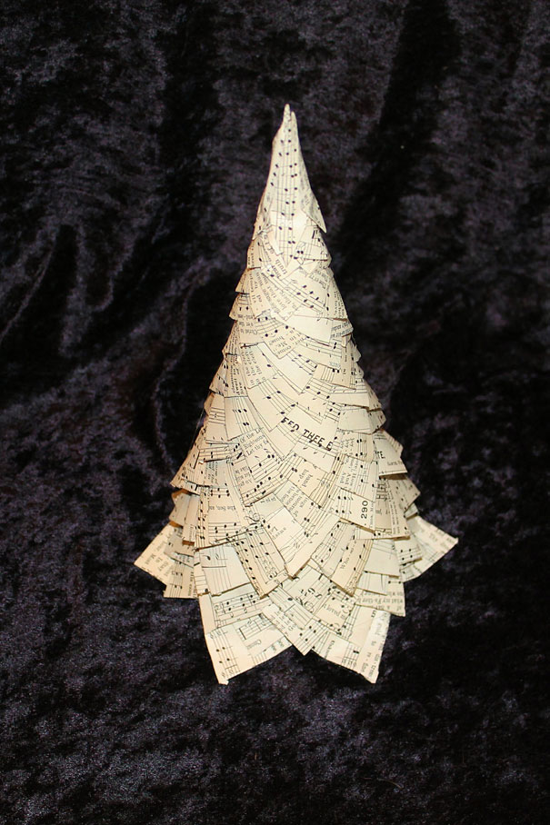 DIY Christmas tree made from layered sheet music on a dark background. DIY Christmas tree made from layered sheet music on a dark background.