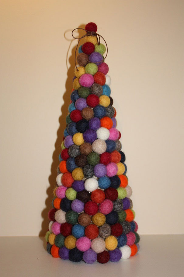 DIY Christmas tree made from colorful felt balls stacked in a cone shape.