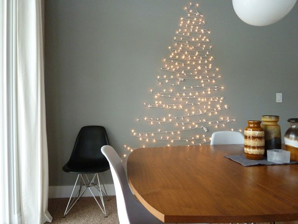 DIY Christmas tree made of twinkling string lights on a wall beside a modern dining table and chairs. DIY Christmas tree made of twinkling string lights on a wall beside a modern dining table and chairs.
