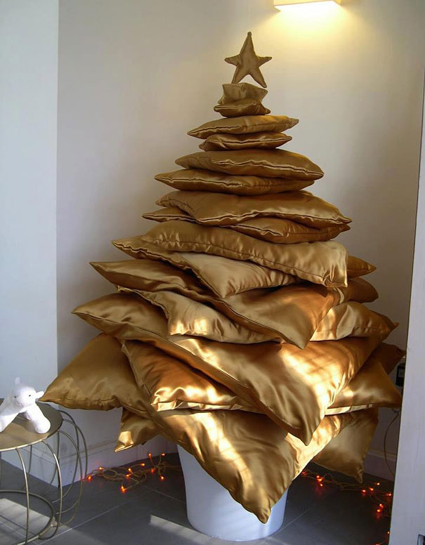 Creative DIY Christmas tree made of stacked gold pillows with a star on top, set in a white corner with soft lighting. Creative DIY Christmas tree made of stacked gold pillows with a star on top, set in a white corner with soft lighting.