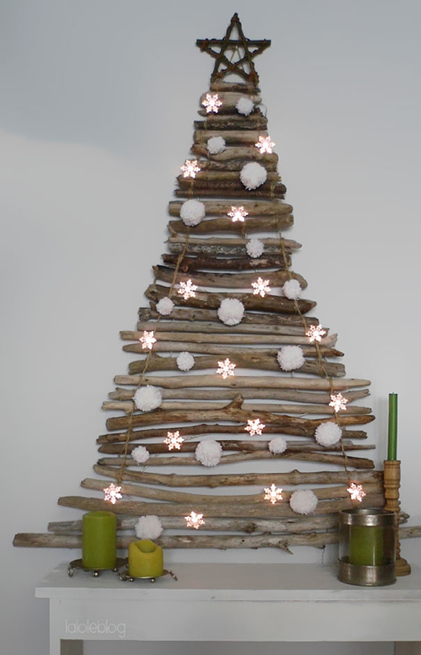 DIY Christmas tree made of stacked driftwood with pom-poms and star lights, decorated on a white mantel. DIY Christmas tree made of stacked driftwood with pom-poms and star lights, decorated on a white mantel.
