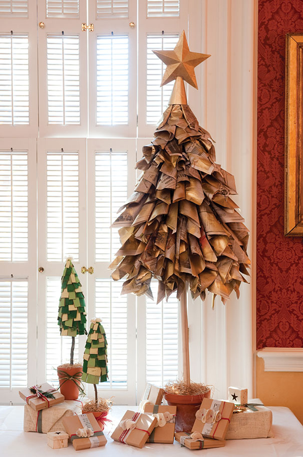 DIY Christmas tree made of folded newspapers with a star on top, surrounded by wrapped gifts.