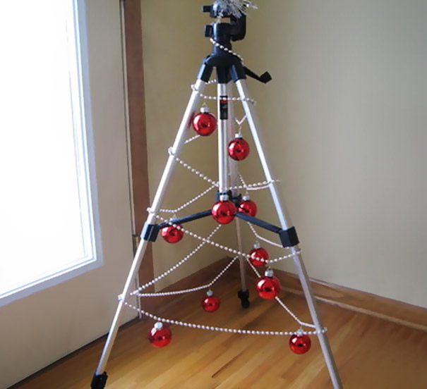 Creative DIY Christmas tree made from a tripod, decorated with red baubles and beads.