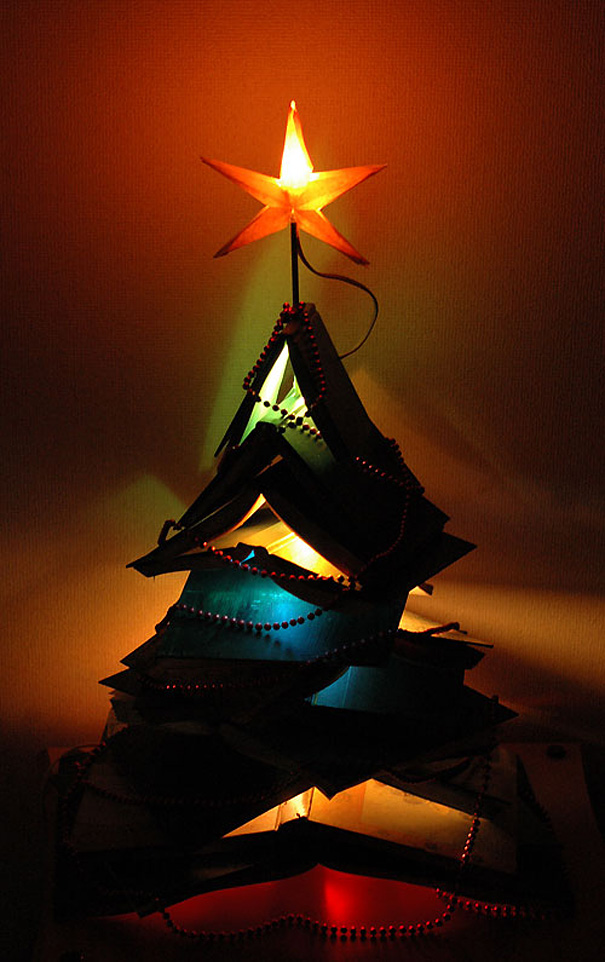 Creative DIY Christmas tree made of colored paper and lit from within, topped with an illuminated star.