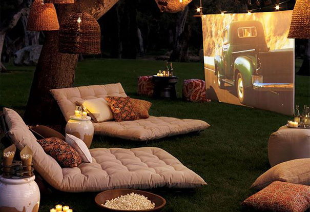 Outdoor cozy seating area with cushions and a projector screen, showcasing amazing design ideas for your house. Outdoor cozy seating area with cushions and a projector screen, showcasing amazing design ideas for your house.