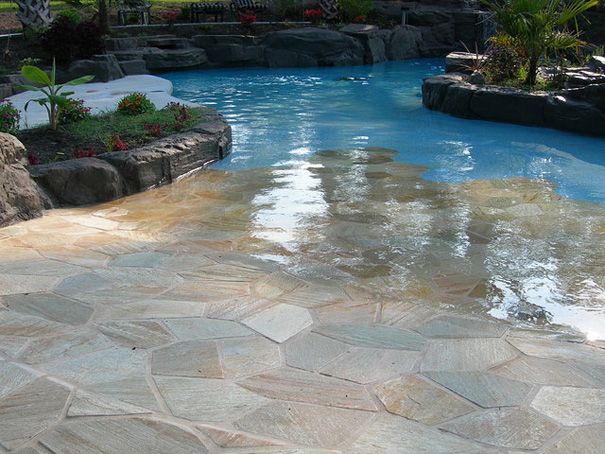 Beautiful pool area with stone patio and tropical landscaping showcasing amazing design ideas for a stylish house exterior. Beautiful pool area with stone patio and tropical landscaping showcasing amazing design ideas for a stylish house exterior.