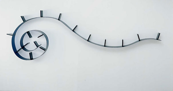 Creative bookshelf design featuring a sleek, spiral wall-mounted shelf with book holders. Creative bookshelf design featuring a sleek, spiral wall-mounted shelf with book holders.