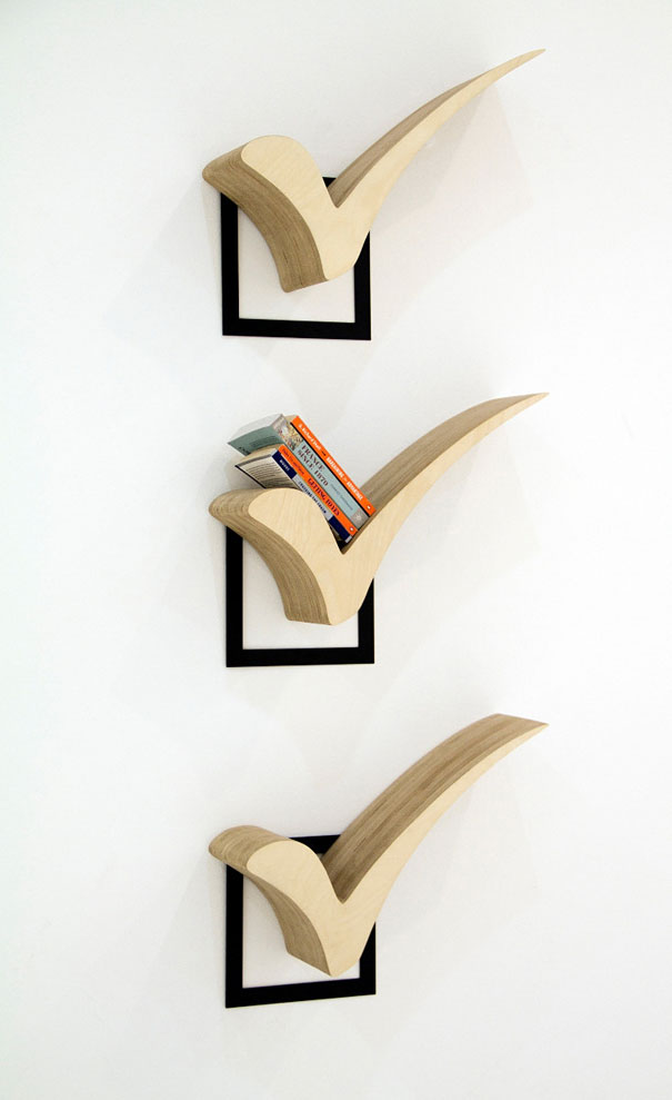 Creative bookshelf designs with checkmark-shaped wooden shelves holding books on a white wall.