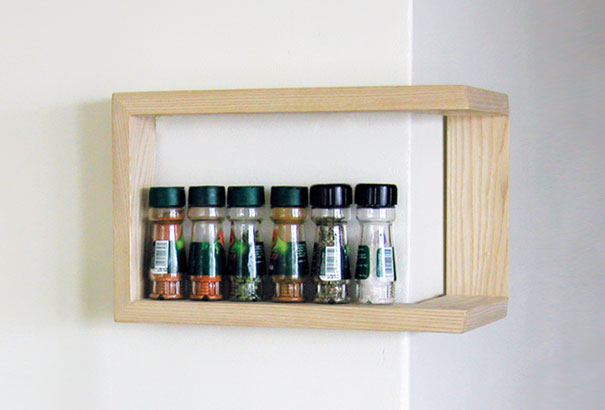 Creative bookshelf design featuring a minimalist wooden frame holding spice jars. Creative bookshelf design featuring a minimalist wooden frame holding spice jars.