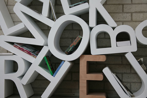 Alphabet-shaped bookshelf design with books placed creatively within the letters.