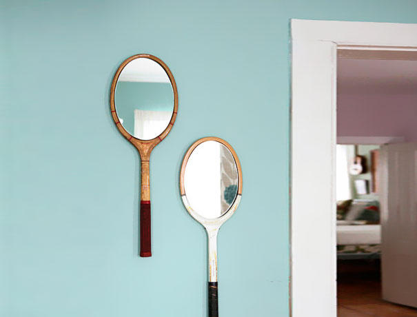 Tennis rackets made into mirror and hanging on the blue wall Tennis rackets made into mirror and hanging on the blue wall