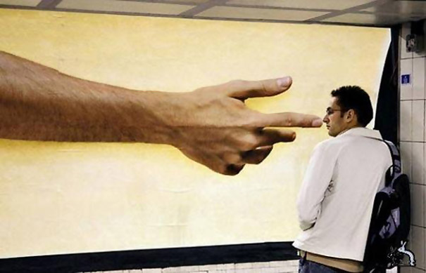 Perfectly timed photo of a man standing next to an advertisement, making it look like a giant hand is pointing at him. Perfectly timed photo of a man standing next to an advertisement, making it look like a giant hand is pointing at him.