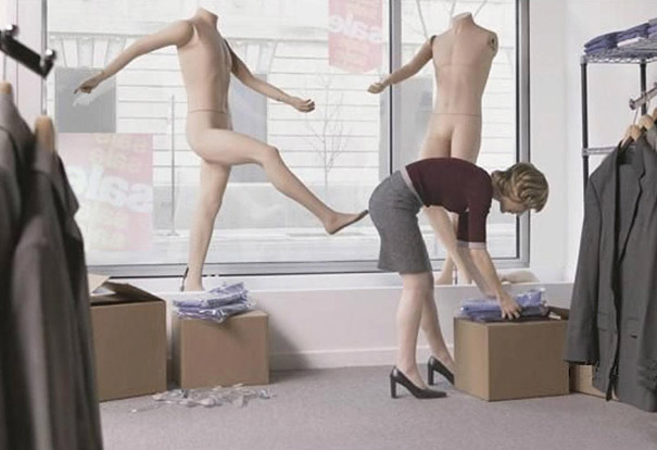 Woman bending near mannequins, creating a perfectly timed photo illusion of being kicked.
