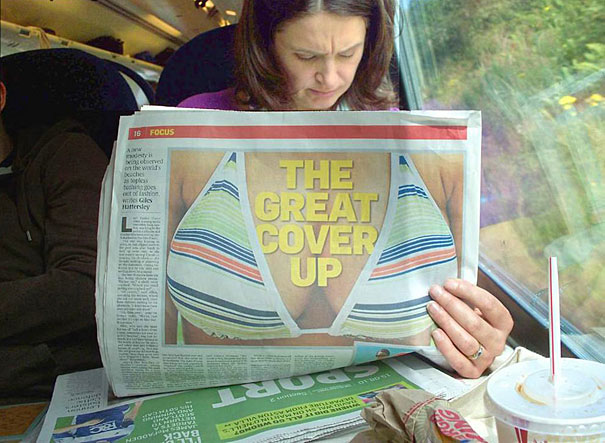 Woman reading a newspaper, bikini photo aligns with her body, creating a perfectly timed optical illusion. Woman reading a newspaper, bikini photo aligns with her body, creating a perfectly timed optical illusion.