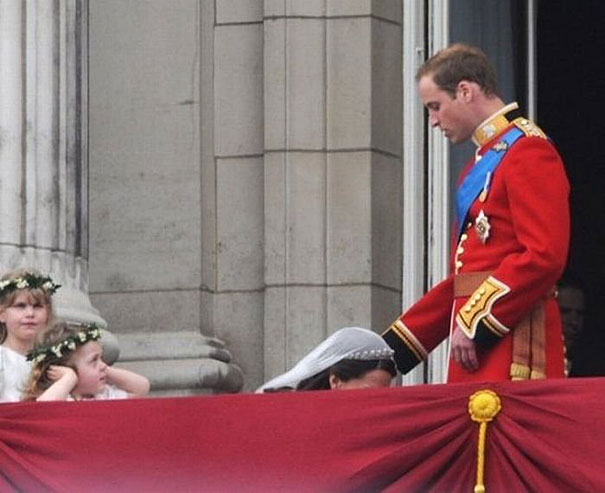 Perfectly timed photo of a person in a red uniform on a balcony with children looking on. Perfectly timed photo of a person in a red uniform on a balcony with children looking on.