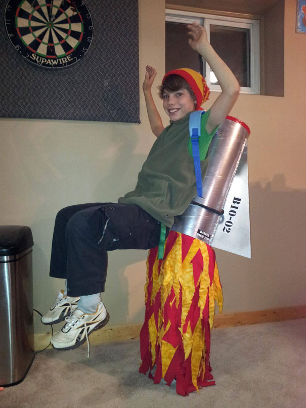 Child in a creative rocket ship costume with flames, embodying fun and imaginative kids' Halloween costumes. Child in a creative rocket ship costume with flames, embodying fun and imaginative kids' Halloween costumes.