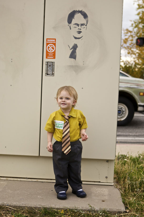 Child in a yellow shirt and striped tie, dressed as a character for a kids' Halloween costume.