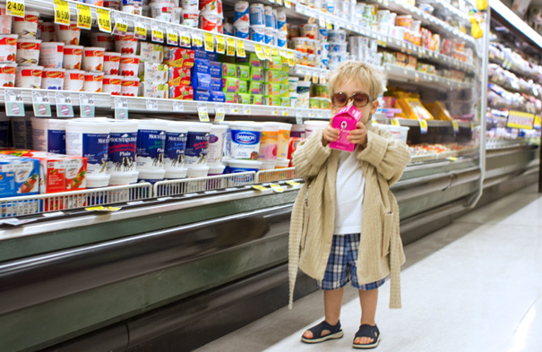 Toddler in sunglasses and robe, holding a beverage in a grocery store aisle, showcasing one of the best kids' Halloween costumes.
