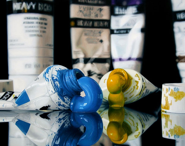 Hyper-realistic artwork of paint tubes squeezing blue and yellow paint onto a reflective surface. Hyper-realistic artwork of paint tubes squeezing blue and yellow paint onto a reflective surface.