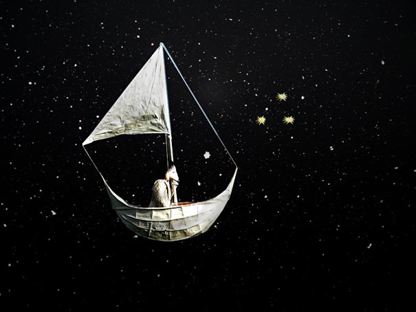 Person sitting in a boat with a sail floating in a starry night sky representing dreams and imagination. Person sitting in a boat with a sail floating in a starry night sky representing dreams and imagination.
