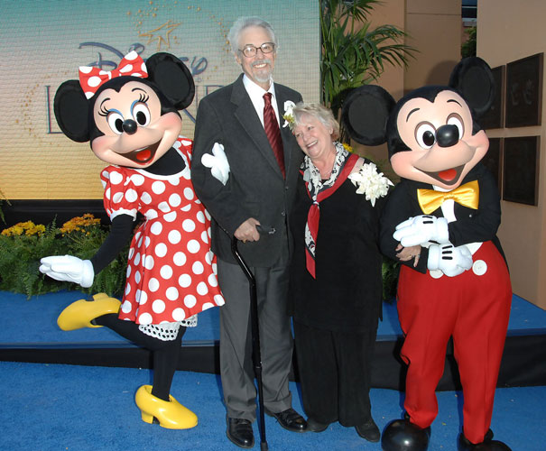 A joyful moment with Mickey and Minnie Mouse posing with two guests at a Disneyland event. A joyful moment with Mickey and Minnie Mouse posing with two guests at a Disneyland event.
