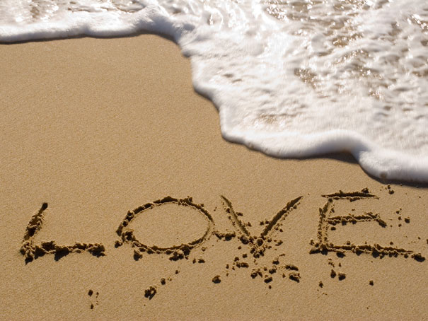 "Love written in sand as wave approaches, symbolizing one of the happiest facts. "Love written in sand as wave approaches, symbolizing one of the happiest facts.