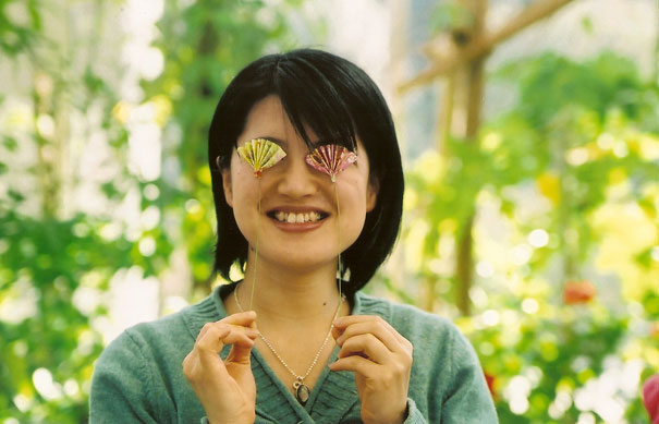 Person smiling with paper fans over eyes, representing one of the happiest moments in life. Person smiling with paper fans over eyes, representing one of the happiest moments in life.