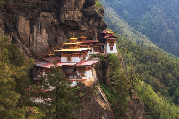 Tiger's Nest Monastery perched on a cliffside, amidst lush forest and mountains, embodies happiness and tranquility.